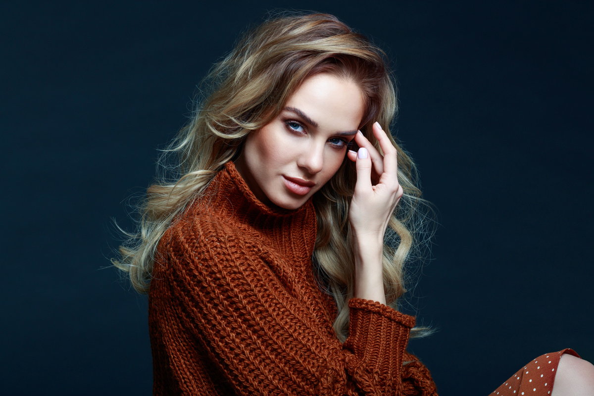 Headshot of blond hair woman in brown sweater